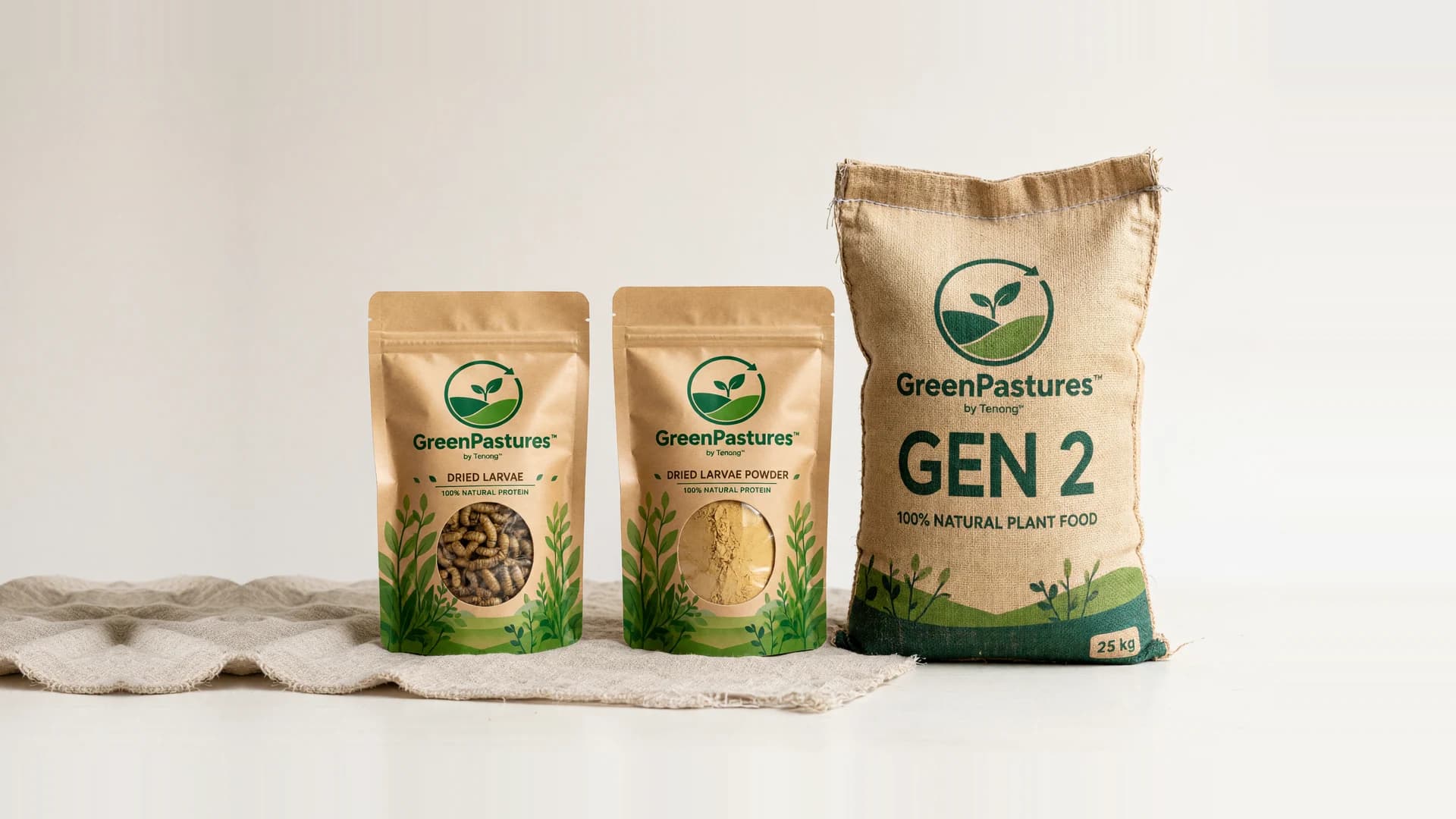 GreenPastures packs on linen: Dried Larvae and Dried Larvae Powder pouches beside a 25 kg Gen 2 sack